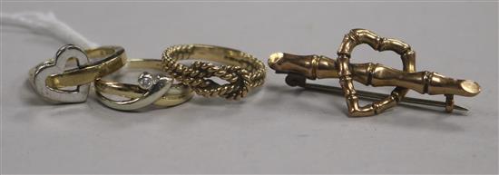 Three 9ct gold rings, one set with a small diamond and a 9ct gold heart and bamboo bar brooch